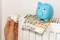 costs of heating apartments in winter in Poland, Energy and economic concept, Hand unscrewing the radiator, piggy bank and Polish