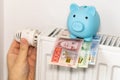 costs of heating apartments in winter in Sweden, Energy and economic concept, Hand unscrewing the radiator, piggy bank and Swedish