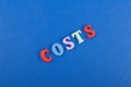 costs word on blue background composed from colorful abc alphabet block wooden letters, copy space for ad text. Learning english Royalty Free Stock Photo