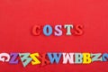 costs word on red background composed from colorful abc alphabet block wooden letters, copy space for ad text. Learning english Royalty Free Stock Photo