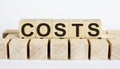 COSTS word from wooden blocks on the desk, search engine optimization concept