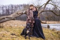 Costume Play. Couple as Knight Warrior and Princess with Black Dog Posing in Medieval Clothing in Spring Forest Outdoors