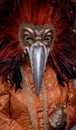 Costumed carnival-goer with red feathered mask standing in St Mark`s Square during Venice Carnival Carnivale di Venezia. Royalty Free Stock Photo