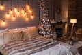 Cosy bedroom with eco decor. Wood and nature concept in interior of room. Scandinavian interior with christmas tree, real photo. H Royalty Free Stock Photo