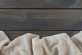 Cosy beige warm wool plaid lie on dark wooden background.