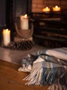 Cosy blanket nearby fire place with candles Royalty Free Stock Photo