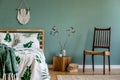 Cosy, boho bedroom interior with wooden bed and chair. Royalty Free Stock Photo