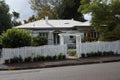 Old, fashioned suburban bungalow home with white picket fence