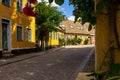 A cosy cobblestoned street in the old parts of the university town of Lund, Sweden. The yellow houses are decorated with lots of