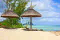 Beautiful tropical white sandy beach with exotic tropical plants,beach umbrellas and sunbeds on traditional mauritian style with a Royalty Free Stock Photo