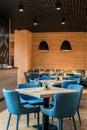 Cosy restaurant european style modern interior with blue chairs and wine glasses on tables , vertical shot Royalty Free Stock Photo