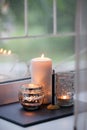 Cosy and soft winter autumn home background, karoma stick and candles on an stone board on windowsill. Christmas or seasonal