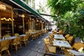 Cosy street with round tables and bright chairs of traditional outdoor French cafe in Paris Royalty Free Stock Photo