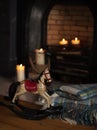 Cosy tartan blanket near fire place with lit candles and vintage Royalty Free Stock Photo