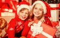 Cosy winter evening together. small kids friends have fun. santa helpers among red present boxes. too much gifts. online