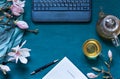 Cosy work space flat lay with magnolia flowers, laptop and green tea,