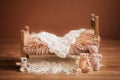 Cot for a newborn on a brown background with toys and a white rug, background
