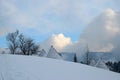 Cotage under the snow, mountains and sky in the back