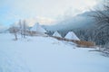 Cotagge under the snow, surounded by wooden fence