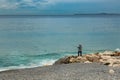 Cote d`Azur coast line with lonely fisherman trying to catch some fish. Tranquin photo with hobby concept