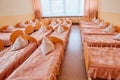 Cots in the kindergarten. Orphanage or boarding school. Beds in a boarding school or in an orphanage Royalty Free Stock Photo