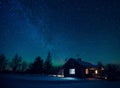 Cottage against the night sky with the Milky Way and the arctic Northern lights Aurora Borealis in snow winter Finland Royalty Free Stock Photo