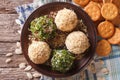 Cottage cheese balls with crackers, herbs and pumpkin seeds close-up. horizontal top view