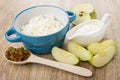 Cottage cheese in bowl, sour cream, pieces of apples, spoon