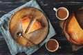 Cottage cheese cake is served on a wooden plate in a rustic style. Coffee, napkin, spoon, wooden background.