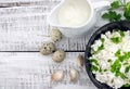 Cottage cheese with chives in black ceramic bowl on rustic woode
