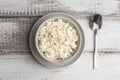 Cottage cheese or curd in bowl and spoon on white wooden rustic table. Healthy organic, diet and farm food Royalty Free Stock Photo