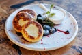 Cottage cheese fritters, curd pancakes or syrniki served with blueberry jam, greek yogurt or sour cream on ceramic plate Royalty Free Stock Photo