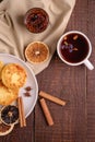 Cottage cheese fritters with hot black aromatic tea with fig jam, Christmas breakfast mood with anise, cinnamon and dried citrus Royalty Free Stock Photo