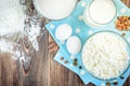 Cottage cheese, glass of milk and eggs on blue fabric and dark wooden table. Protein product Royalty Free Stock Photo