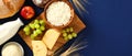 Cottage cheese, milk bottle. grape, bread, wheat on blue background. Happy Shavuot, harvest concept