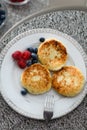 Cottage cheese pancakes with blueberries and raspberries and sour cream Royalty Free Stock Photo