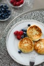 Cottage cheese pancakes with blueberries and raspberries and sour cream Royalty Free Stock Photo