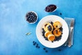 Cottage cheese pancakes or curd fritters decorated honey and blueberry in plate on blue table top view. Healthy and diet breakfast Royalty Free Stock Photo