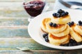 Cottage cheese pancakes or curd fritters decorated honey and blueberry in plate on rustic table. Delicious and diet breakfast.