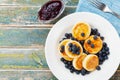 Cottage cheese pancakes or curd fritters with honey and blueberry in plate on rustic table top view. Delicious and diet breakfast.