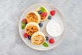 Cottage cheese pancakes with fresh berries, sour cream and honey on a gray concrete background. Royalty Free Stock Photo