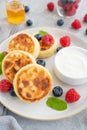 Cottage cheese pancakes with fresh berries, sour cream and honey on a gray concrete background. Royalty Free Stock Photo