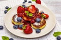 Cottage cheese pancakes with fresh berries and strawberry sauce. Healthy breakfast concept on wooden background Royalty Free Stock Photo