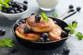 Cottage cheese pancakes served in cast iron frying pan with blueberries and mint leaves. Healthy breakfast food. Royalty Free Stock Photo