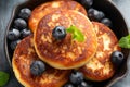 Cottage cheese pancakes served in cast iron frying pan with blueberries and mint leaves. Healthy breakfast food. Royalty Free Stock Photo