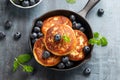 Cottage cheese pancakes served in cast iron frying pan with blueberries and mint leaves. Healthy breakfast food. Royalty Free Stock Photo