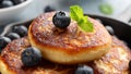 Cottage cheese pancakes served in cast iron frying pan with blueberries and mint leaves. Healthy breakfast food. Royalty Free Stock Photo