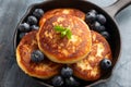 Cottage cheese pancakes served in cast iron frying pan with blueberries and mint leaves. Healthy breakfast food. Royalty Free Stock Photo