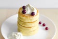 Cottage cheese pancakes with sour cream and berries on rustic ba