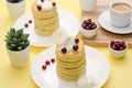 Cottage cheese pancakes with sour cream and berries on yellow ba
